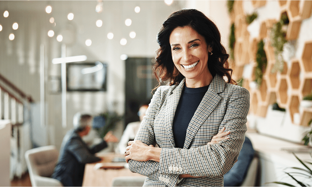 Smiling woman in office with colleagues.