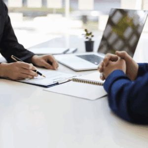 Professional signing documents across a desk
